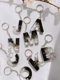 the letters have been made out of glass and are hanging from chains on a white surface