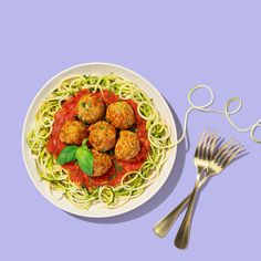 a white plate topped with spaghetti and meatballs next to a fork, knife and spoon