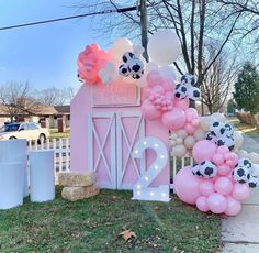 a pink barn decorated with balloons and decorations