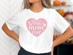 a woman wearing a t - shirt with the words best mom ever printed on it