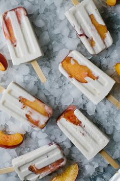 several popsicles with peaches and ice cream on them sitting on top of crushed ice