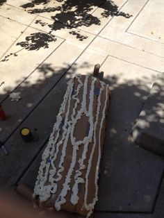 a piece of cardboard sitting on top of a sidewalk next to a fire hydrant