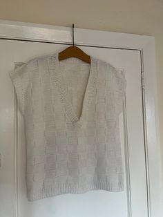 "women's hand knitted sleeveless off white chunky sweater jumper  Made of wool but not sure exactly which kind perhaps an acrylic mix Rib knit on the hem and armholes and neckline  can be worn by either men or women  size M/L 21\" armpit to armpit across the front although there is some stretch  25\" long from neck at the back to hem  can also be worn oversized  Excellent preloved condition" White Chunky Knit V-neck Top, White Textured Knit V-neck Sweater Vest, Cozy Cotton Crew Neck Sweater Vest, Trendy Textured Knit Crew Neck Sweater Vest, White Knitted Vest For Fall, Sleeveless Knitted Cotton Sweater, Trendy Fitted Textured Knit Sweater Vest, Fall White Knitted Vest, Cozy Sleeveless Cotton Tops