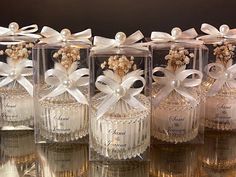 several clear bottles with bows and pearls on them