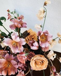 a vase filled with lots of flowers on top of a table