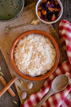 a bowl of oatmeal with nuts and raisins on the side