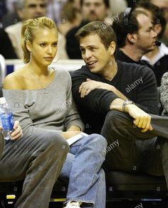 a man and woman sitting next to each other at a basketball game