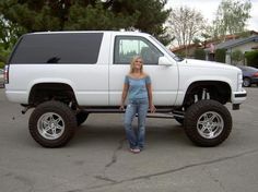 a woman standing in front of a white truck