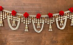 a garland with red roses and bells hanging from it