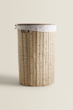 an empty wicker basket with a white lid on a grey background, showing the interior