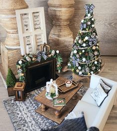 a living room filled with furniture and christmas tree decorations on top of a wooden table