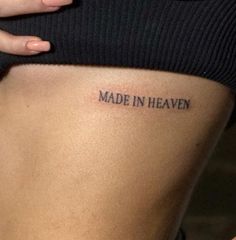 a woman's stomach with the words made in heaven tattooed on it