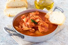 a bowl of soup with bread on the side