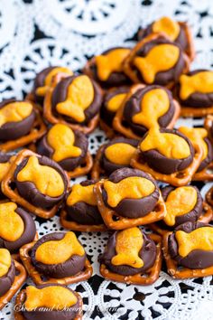 chocolate covered pretzels are arranged on a doily with orange and brown icing