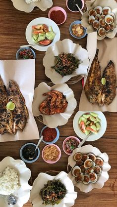 a table topped with lots of different types of food on paper plates and bowls next to each other