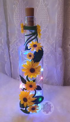 a glass bottle with sunflowers in it