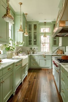 a large kitchen with green cabinets and wood flooring, along with white counter tops