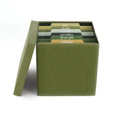 a green file box filled with files on top of a white surface