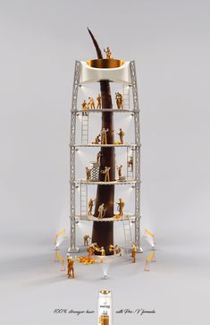 a tall metal tower with many figurines on it's sides and a wine bottle in the middle