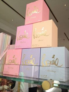 several boxes stacked on top of each other with gold lettering and names in different colors