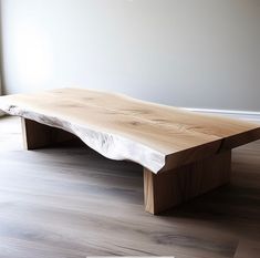 a large wooden table sitting on top of a hard wood floor next to a window