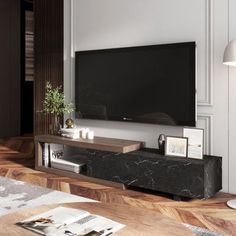 a living room with a large television on the wall next to a coffee table and lamp