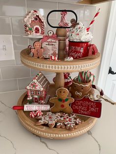 three tiered tray with gingerbread cookies, candy canes and other holiday decorations