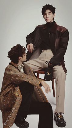 two men sitting next to each other on top of a chair