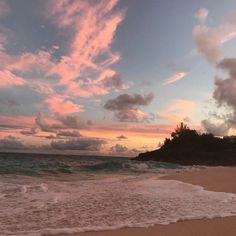 the sun is setting at the beach with waves coming in