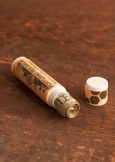 a tube of glue sitting on top of a wooden table next to an empty container