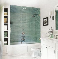 a white bathroom with blue tiles on the walls and floor is featured in an instagram