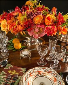 the table is set with orange and red flowers