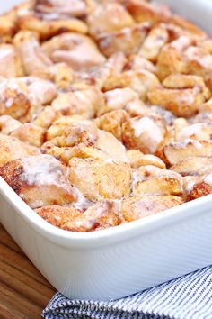 cinnamon rolls in a white baking dish on a wooden table