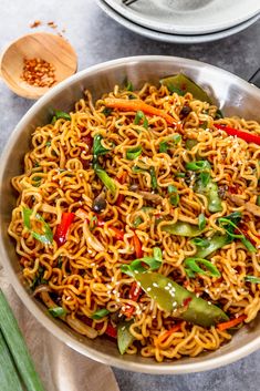 a bowl filled with noodles and vegetables on top of a table