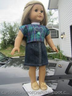 a doll standing on top of a car