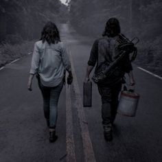 two people walking down the road with luggage