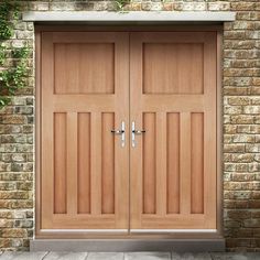 two wooden double doors in front of a brick wall