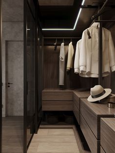 a walk - in closet with clothes hanging on the wall and two hats sitting on drawers