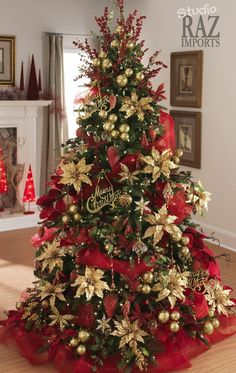 a christmas tree decorated with gold and red ribbons, poinsettis and bows