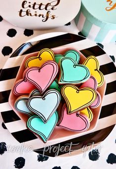 some heart shaped cookies are on a plate with black and white polka dot tablecloth