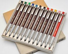 several pens are lined up in a box on top of each other with different colors