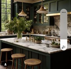 an image of a kitchen setting with green cabinets and marble counter tops in the center