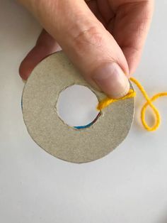 someone is making a paper circle with yarn