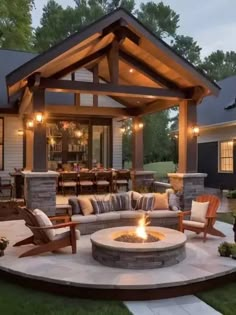 a fire pit sitting in the middle of a patio surrounded by lawn furniture and lights