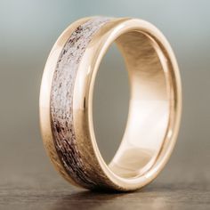 a gold wedding ring with antler wood inlay