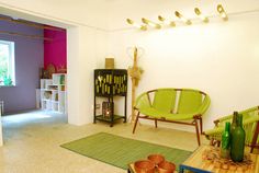 a living room filled with furniture and lots of green accents on the walls in front of a window