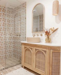 a bathroom with a sink, mirror and shower stall in it's own area