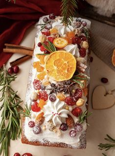 a cake with oranges, cranberries and nuts on it sitting next to other decorations