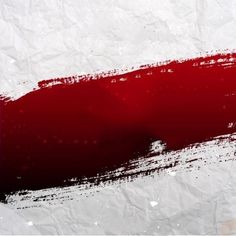 a piece of paper with some red and white paint splattered on it's surface