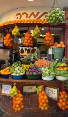 an outdoor fruit stand with oranges and other fruits